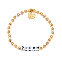 gold bead bracelet from Little Words Project that reads, "DREAM."