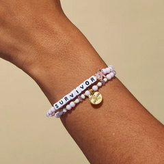 American Cancer Society Little Words Project bead bracelet that says, "SURVIVOR" with the breast cancer pink ribbon.