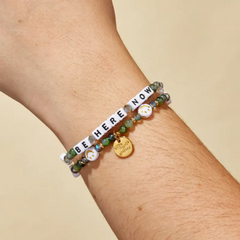 Green colored bead bracelet with white smiling faces, from Little Words Project. Be Here Now Bracelet.