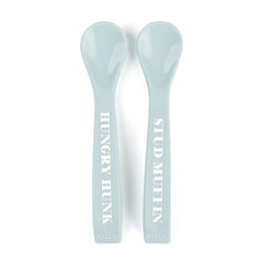 A set of 2 baby spoons in the color blue. One spoon reads, "Hungry Hunk." The other spoon reads, "Stud Muffin." This spoon set comes from the brand Bella Tunno.