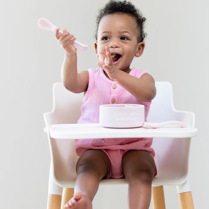 A set of 2 baby spoons in the color pink. One spoon reads, "All Hail The Queen." The other spoon reads, "Little Miss Fabulous ." This spoon set comes from the brand Bella Tunno.