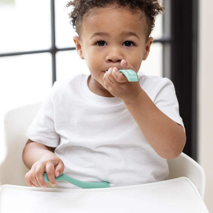 A set of 2 baby spoons in the color green. One spoon reads, "Yummy in my tummy." The other spoon reads, "moody without foody." This spoon set comes from the brand Bella Tunno.