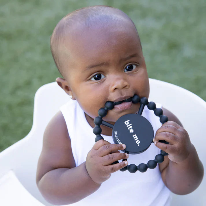 Black color Happy Teether that reads, "bite me" in the middle. The teether is made from silicone, and comes from the brand Bella Tunno.