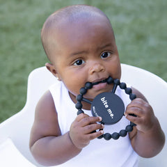 Black color Happy Teether that reads, "bite me" in the middle. The teether is made from silicone, and comes from the brand Bella Tunno.
