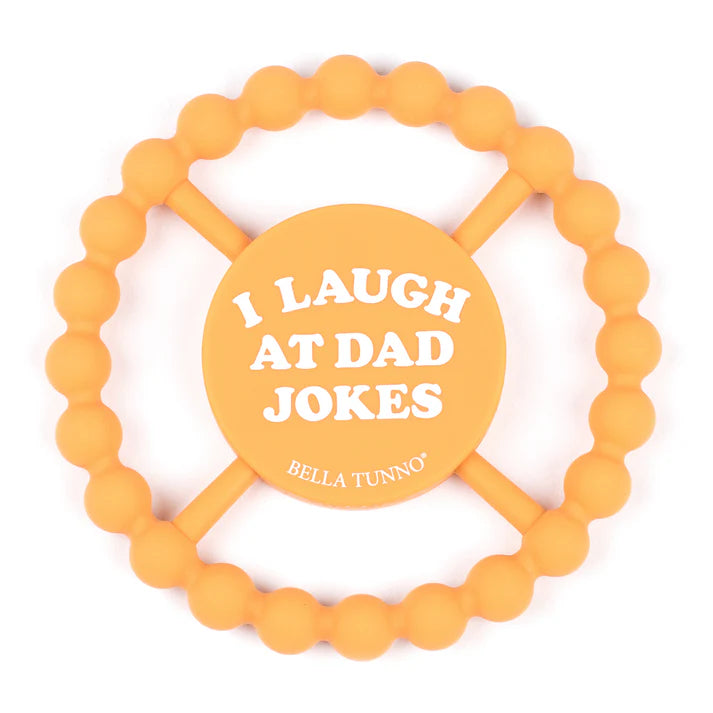 Orange color Happy Teether that reads, "I LAUGH AT DAD JOKES" in the middle. The teether is made from silicone, and comes from the brand Bella Tunno.