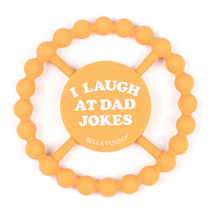 Orange color Happy Teether that reads, "I LAUGH AT DAD JOKES" in the middle. The teether is made from silicone, and comes from the brand Bella Tunno.
