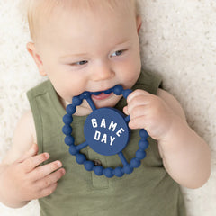 BLUE color Happy Teether that reads, "GAME DAY" in the middle. The teether is made from silicone, and comes from the brand Bella Tunno.