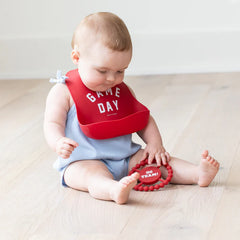 Red color Happy Teether that reads, "GO TEAM!" in the middle. The teether is made from silicone, and comes from the brand Bella Tunno.