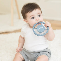 Blue color Happy Teether that reads, "HUNK" in the middle. The teether is made from silicone, and comes from the brand Bella Tunno.