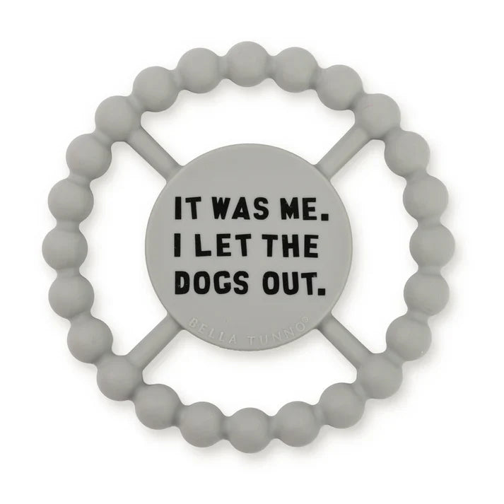 Grey color Happy Teether that reads, "IT WAS ME. I LET THE DOGS OUT" in the middle. The teether is made from silicone, and comes from the brand Bella Tunno.