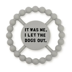 Grey color Happy Teether that reads, "IT WAS ME. I LET THE DOGS OUT" in the middle. The teether is made from silicone, and comes from the brand Bella Tunno.