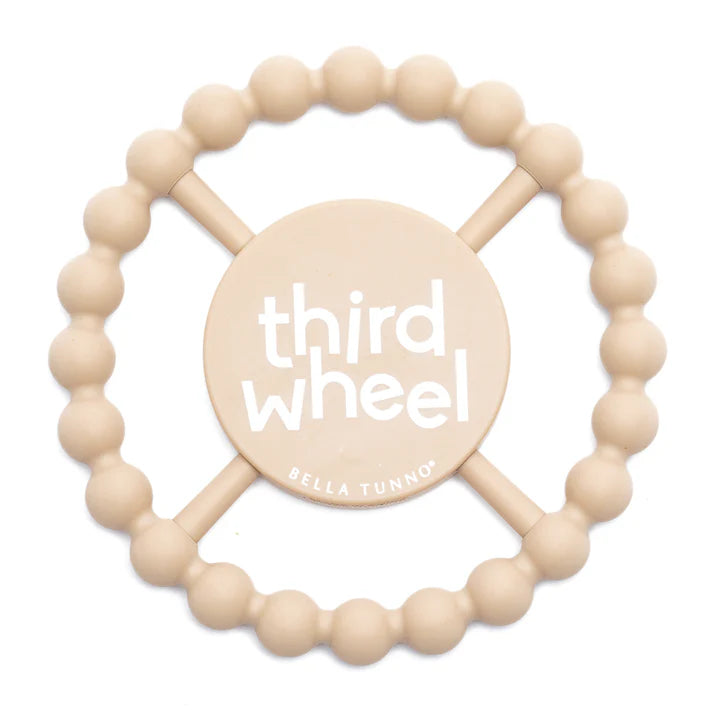 TAN color Happy Teether that reads, "THIRD WHEEL" in the middle. The teether is made from silicone, and comes from the brand Bella Tunno.