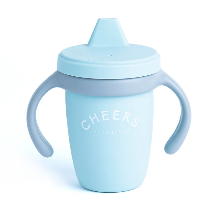 A blue color sippy cup, with gray handles. The sippy cup reads, "Cheers" with the Bella Tunno logo at the bottom.