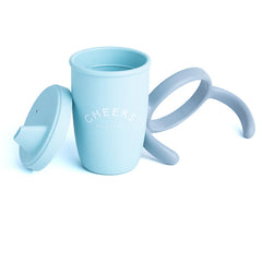 A blue color sippy cup, with gray handles. The sippy cup reads, "Cheers" with the Bella Tunno logo at the bottom.