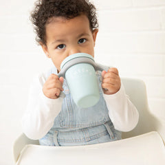 A blue color sippy cup, with gray handles. The sippy cup reads, "Cheers" with the Bella Tunno logo at the bottom.