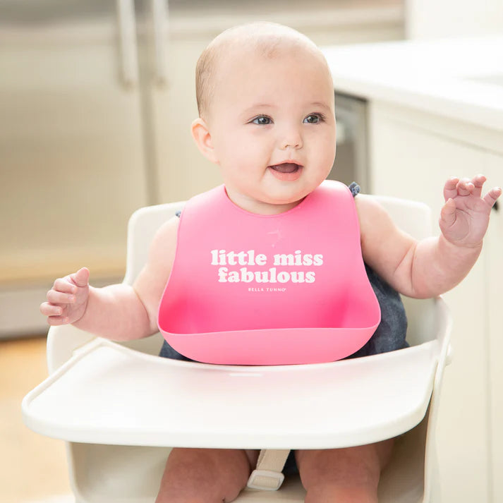 Pink color Wonder Bib that reads, "little miss fabulous" with the Bella Tunno logo below it. The bib is adjustable in size with 4 snaps that easily fit around the neck. The Wonder Bib is designed out of silicone, and is made by Bella Tunno.