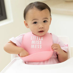 Pink color Wonder Bib that reads, "little miss mess" with the Bella Tunno logo below it. The bib is adjustable in size with 4 snaps that easily fit around the neck. The Wonder Bib is designed out of silicone, and is made by Bella Tunno.