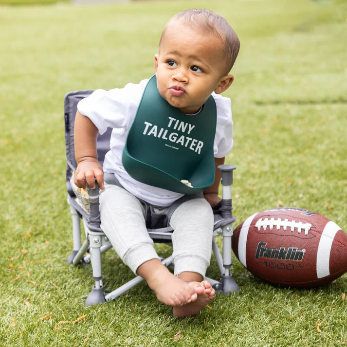 Green color Wonder Bib that reads, "Tiny Tailgater" with the Bella Tunno logo below it. The bib is adjustable in size with 4 snaps that easily fit around the neck. The Wonder Bib is designed out of silicone, and is made by Bella Tunno.