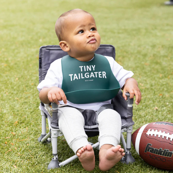 Green color Wonder Bib that reads, "Tiny Tailgater" with the Bella Tunno logo below it. The bib is adjustable in size with 4 snaps that easily fit around the neck. The Wonder Bib is designed out of silicone, and is made by Bella Tunno.