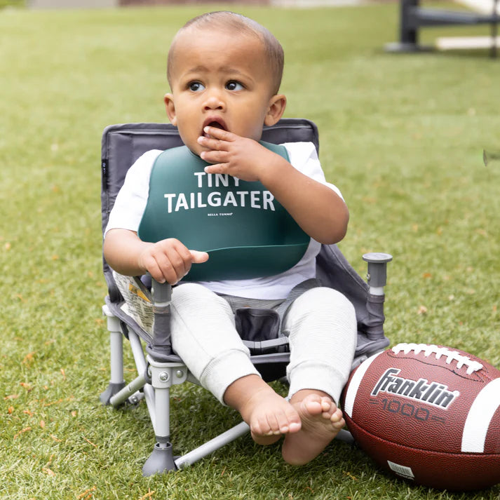 Green color Wonder Bib that reads, "Tiny Tailgater" with the Bella Tunno logo below it. The bib is adjustable in size with 4 snaps that easily fit around the neck. The Wonder Bib is designed out of silicone, and is made by Bella Tunno.