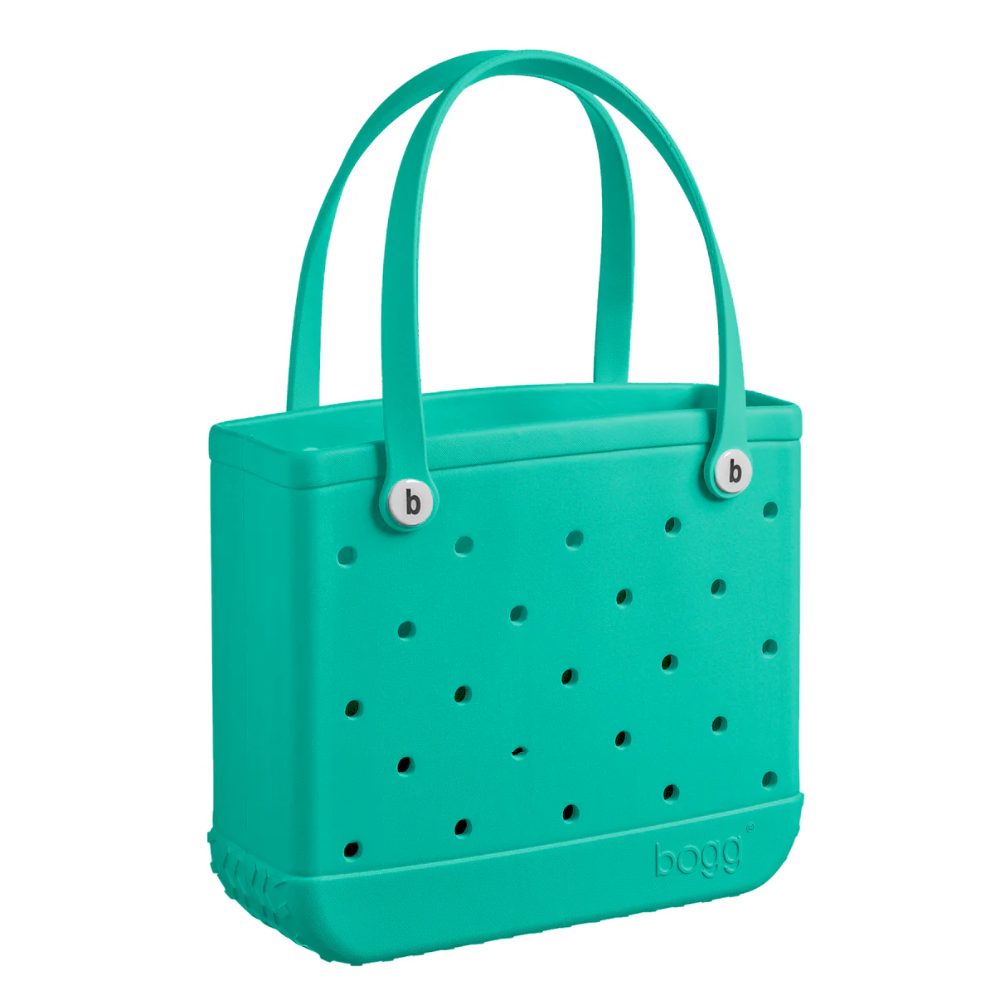 A green color handbag with holes on the side and two handle straps on top from Bogg Bag. There's a Bogg logo engraved into the bottom of the bag.