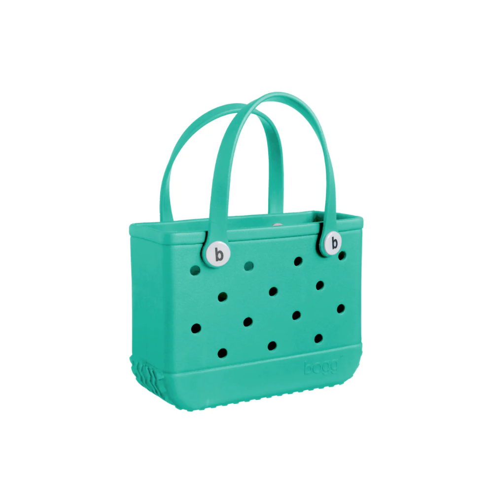 A green hand bag with holes in the side, with double hand straps on top, and a Bogg Bag logo engraved into the bottom right of the bag.