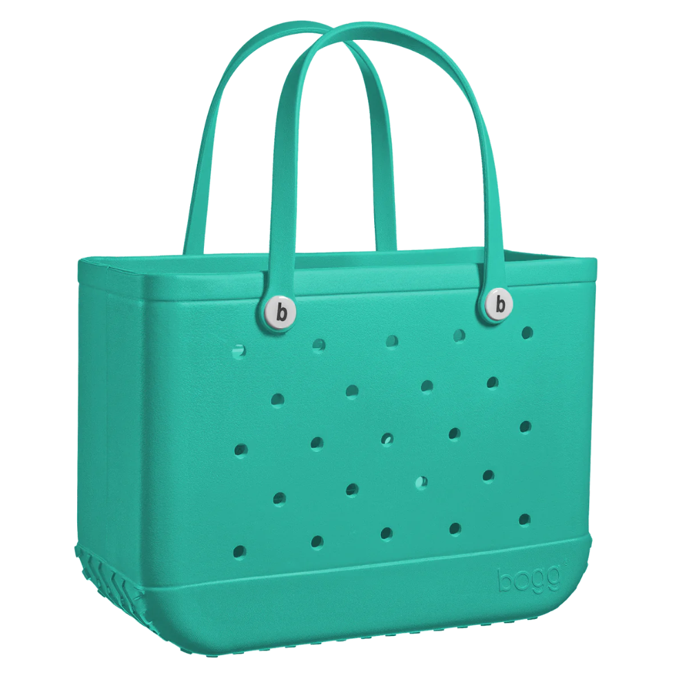 A green colored hand bag with holes on the side, and two handles on top. The bag features a Bogg Bag logo on the bottom right engraved into the bag.