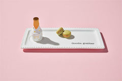 The Light up sitter of champagne sitting on a white colored cookie platter.