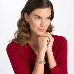 A model wearing a red shirt, showing the Candy Cane Mini Post Earrings in her right ear.