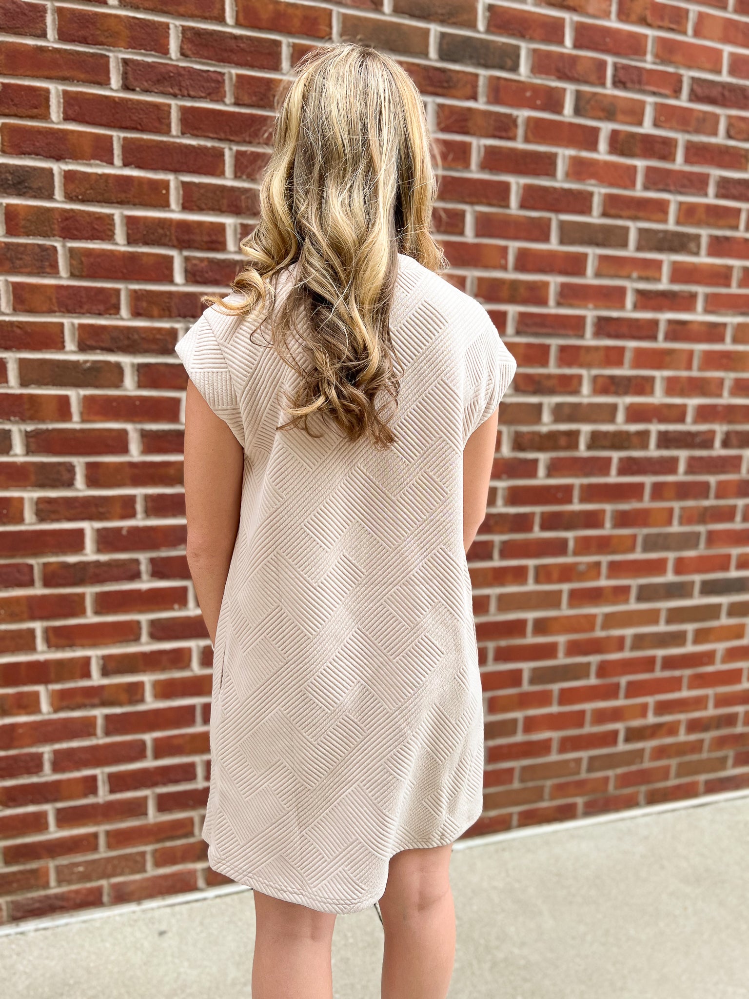 The back view of a tan dress with short sleeves from Daisy Mercantile.