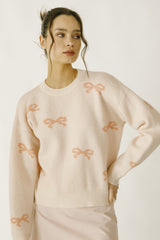 Daisy Mercantile Bow Knit Sweater, with pink ribbons all around the sweater.