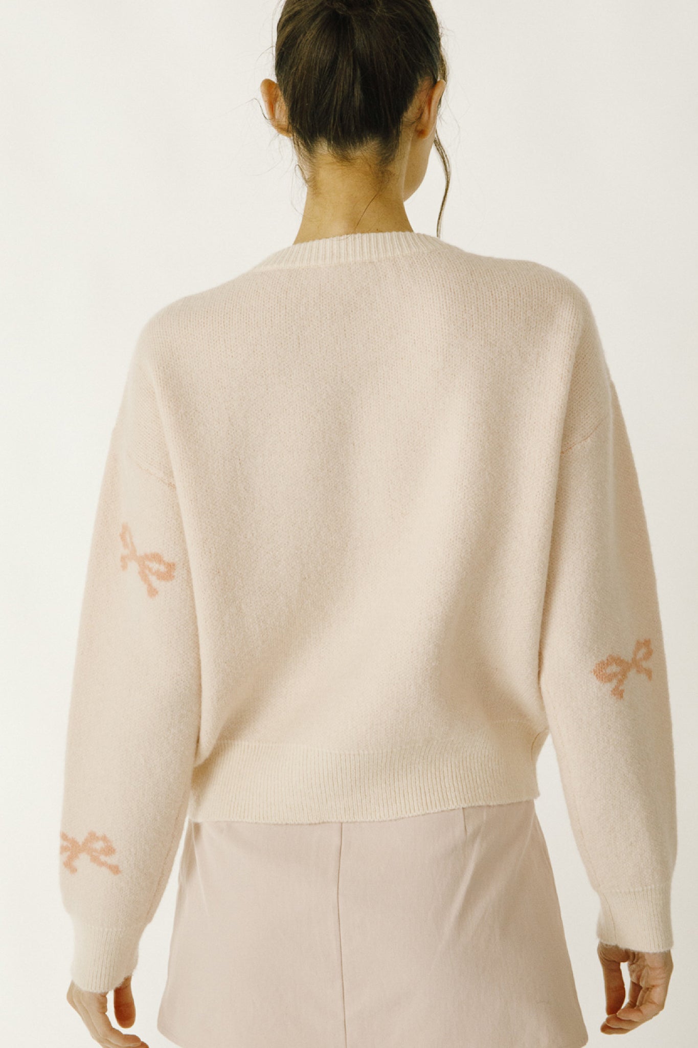 Daisy Mercantile Bow Knit Sweater, with pink ribbons all around the sweater.