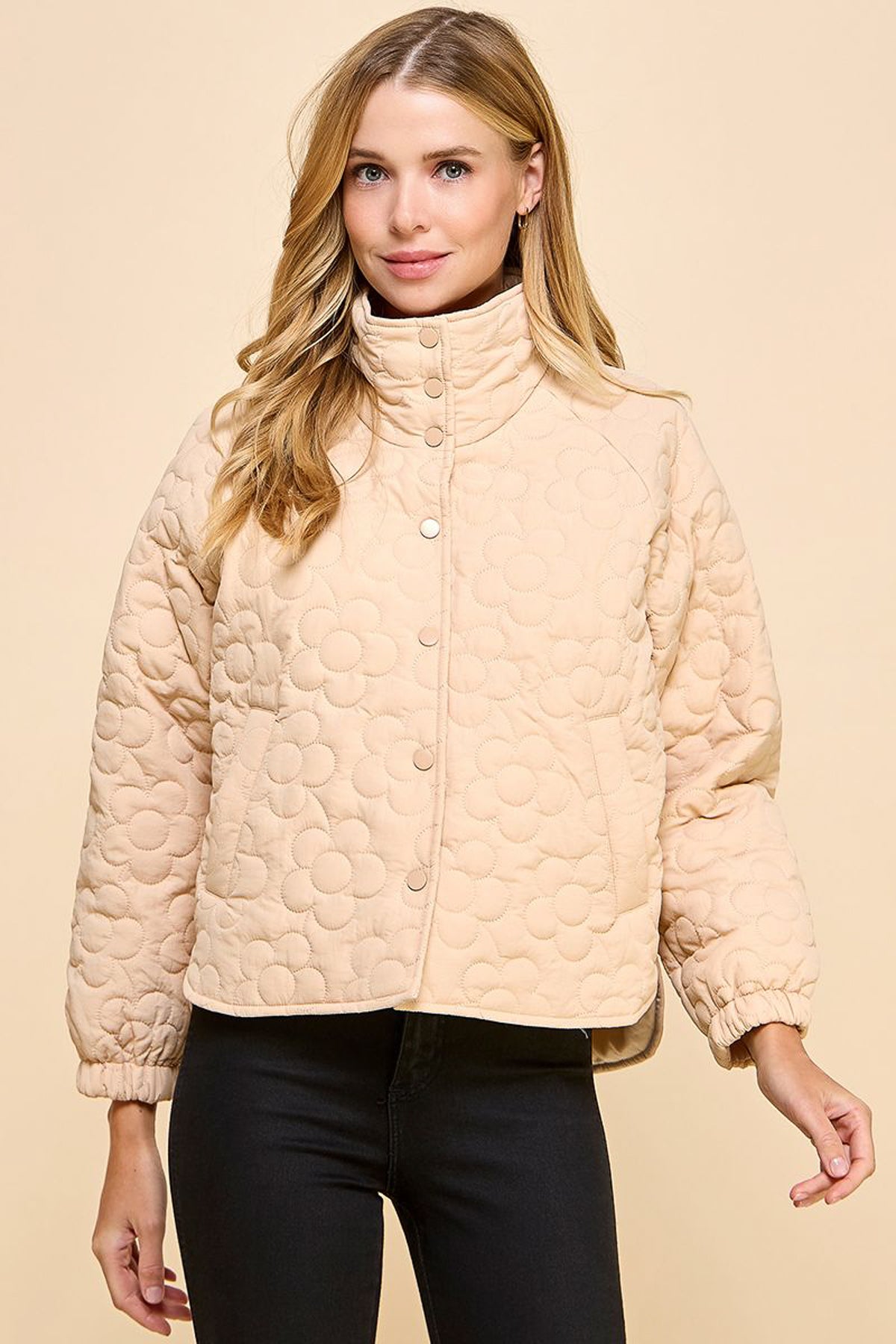 Beige color jacket that buttons up all the way up to the neck, with flower print etched into the jacket.