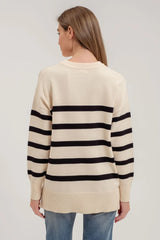 White women's sweater with 5 black stripes.