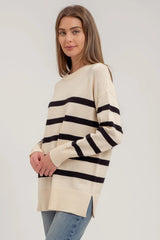 White women's sweater with 5 black stripes.