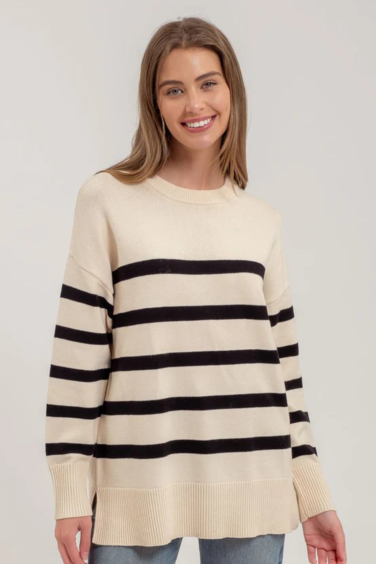 White women's sweater with 5 black stripes.