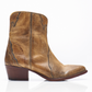 Women's western style boot from the brand Free People. The boot is the color tan.