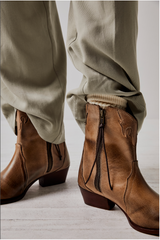 Women's western style boot from the brand Free People. The boot is the color tan.