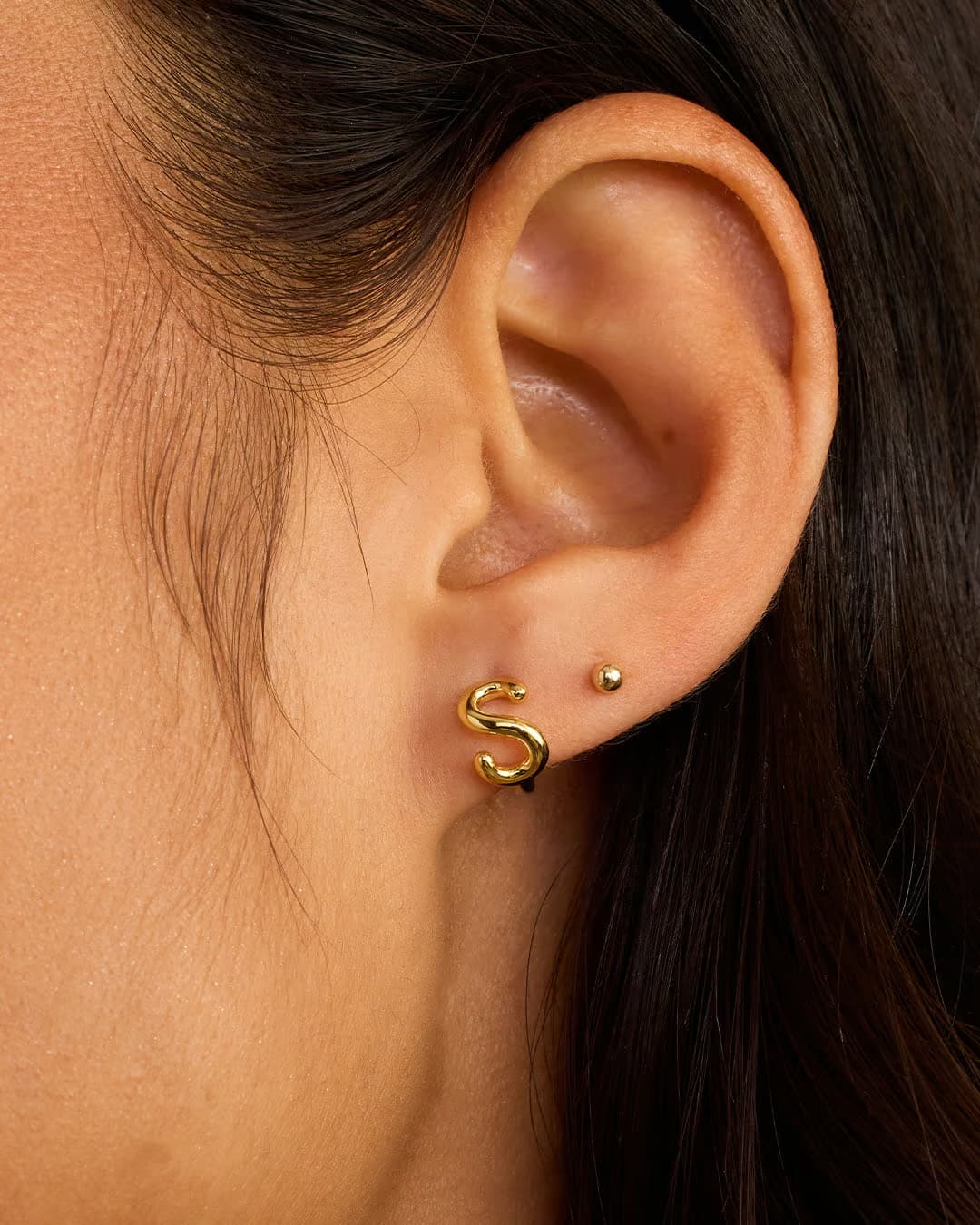 18k gold plated Initial S huggie earring from the jewelry brand Gorjana.