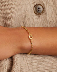 Gold chain bracelet with a mini heart closure from the brand of Gorjana. The gold is 18k gold plated.