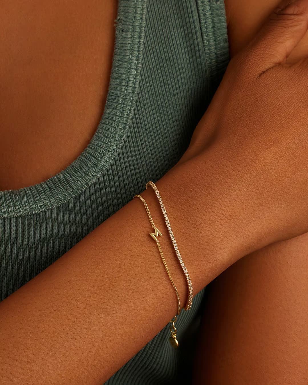 Adjustable gold bracelet with the letter M charm. The bracelet is from the jewelry brand Gorjana.