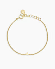 Adjustable gold bracelet with the letter A charm. The bracelet is from the jewelry brand Gorjana.