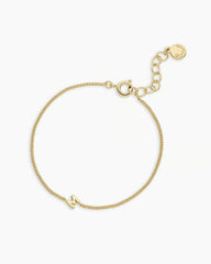 Adjustable gold bracelet with the letter M charm. The bracelet is from the jewelry brand Gorjana.