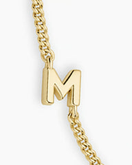 Adjustable gold bracelet with the letter M charm. The bracelet is from the jewelry brand Gorjana.