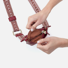 Cass Phone Crossbody in the color wine from the brand HOBO. The phone crossbody is made from pebbled leather.