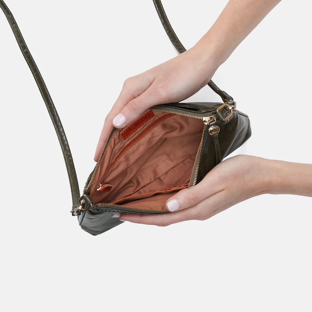Darcy Crossbody bag designed out of polished leather in the color deep moss (green). This crossbody is from the handbag brand HOBO.
