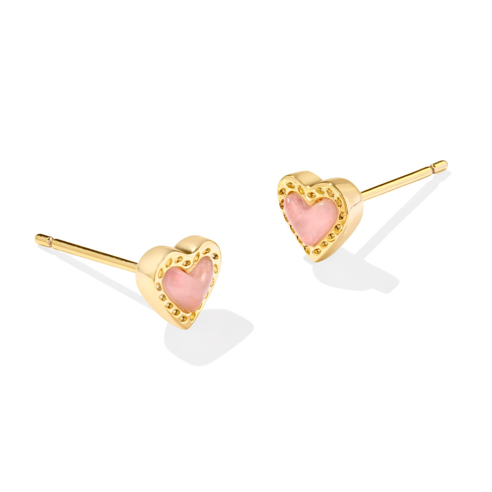 Gold heart shape stud earrings with a pink charm in the middle, from the jewelry brand Kendra Scott.