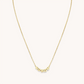 A gold chain necklace from Little Words Project. The necklace includes gold beads that read, TRUST.