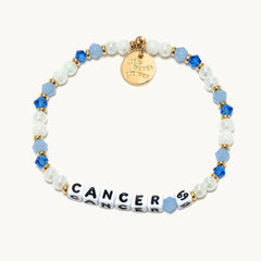 A gold and blue beaded bracelet from Little Words Project®, with the Cancer zodiac symbol.