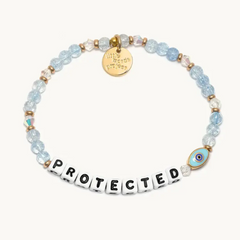 Blue bead bracelet that says, "PROTECTED" and has an evil eye symbol.